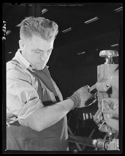 Production. Aircraft. A precision machinist in the machine shop of a large Western aircraft factory. Since variation from perfection may mean a jammed gun, a faulty landing-gear or a stalled engine, men like this are now at an all time premium