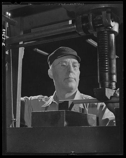 Production. Aircraft. A precision machinist in the machine shop of a large Western aircraft factory. Since variation from perfection may mean a jammed gun, a faulty landing-gear or a stalled engine, men like this are now at an all time premium