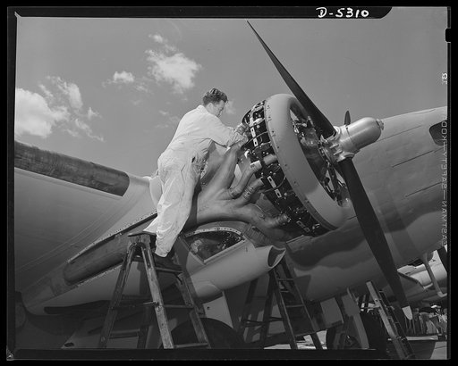 Production. Aircraft. A mechanic in the flight test group of a large Western aircraft factory checks the power plant of a Lockheed "Hudson" bomber after its initial flight