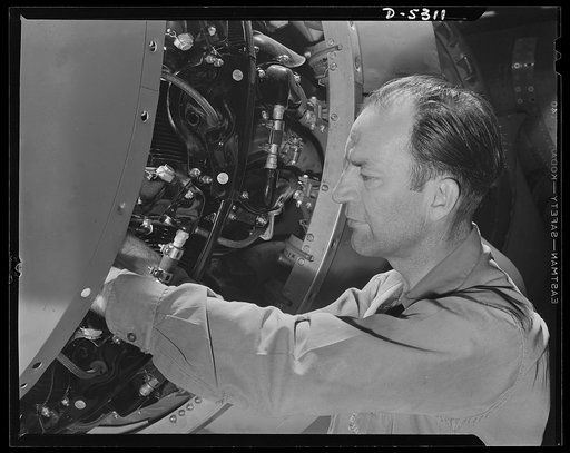 Production. Aircraft. A mechanic tightens up connections on the power plant of a Ventura as the ship nears the end of Vega's assembly line