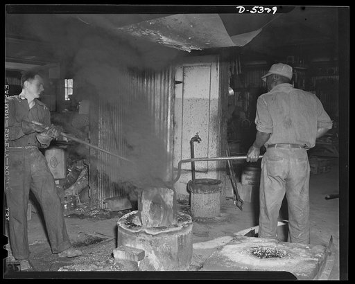 DeLand pool. Improvised foundry, Daytona Beach. Important workers in the DeLand, Florida, industrial pool. R.G. Campbell, foundry foreman, and his Negro helper, Arthur Brown, who used to work in an orange grove, draw the homemade crucible, filled with molten metal, out of the tiny blast furnace impr