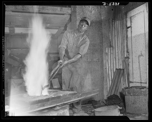 DeLand pool. Improvised foundry, Daytona Beach. Charging the aluminum furnace in the improvised foundry built at Daytona Beach, Florida, by city fireman J.L. Clayton. Old auto crankcases, pots, pans--any solid form of aluminum--is dropped into the homemade crucible for remelting and casting into exp