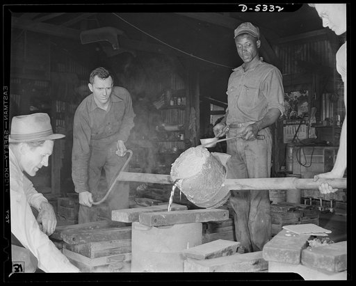 DeLand pool. Improvised foundry, Daytona Beach. Molten aluminum spills like quicksilver from this homemade bucket-sized ladle and pours white-hot into a mold to cast experimental parts for bombers in Clayton's foundry at Daytona Beach, Florida. Foundry foreman R.G. Campbell watches the color of the 