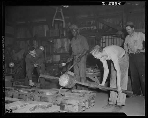 DeLand pool. Improvised foundry, Daytona Beach. The "pour" in a foundry at Daytona Beach, Florida, designed by city fireman J.L. Clayton. R.G. Campbell, foundry foreman, left, is controlling the homemade ladle. Arthur Brown, Negro helper from an orange grove, guides the crucible, while Lewis Pillitz
