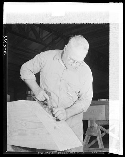 Production. Subchasers. The foreman of the keel department of an Eastern shipyard does a final planing job on a timber for a new subchaser. He has been a shipbuilder all his life and is well known for the fishing boats he has turned out. He came out of retirement to give his skill and experience to 