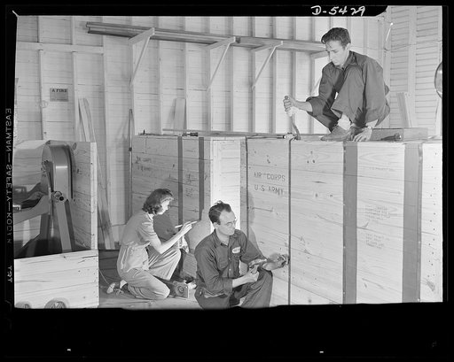 De Land pool. Babcock airplane plant. The last operation in the De Land, Florida industrial pool is buttoning up the huge motor repair racks in their packing crates, sealing them against everything from sand to seawater. Left is Mary Babcock, daughter of plant owner, who never dreamed she would be p
