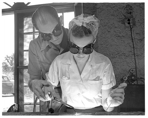 De Land pool. Aircraft construction class. Clyde Williams, instructor in the Daytona Beach, Florida Vocational School, guides the hands of Marie Myers in the first steps of becoming an aircraft welder. Marie was a high school student taking a business course, when she gave it up for defense training