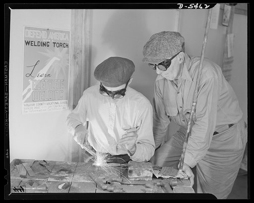 De Land pool. Aircraft construction class. A De Land, Florida fruit buyer and a carpenter, both over fifty, now doing aircraft welding which is passing army inspectors without a single rejection. Typical of the men of De Land who went into war production are John W. Smith, left, fifty-two, with five