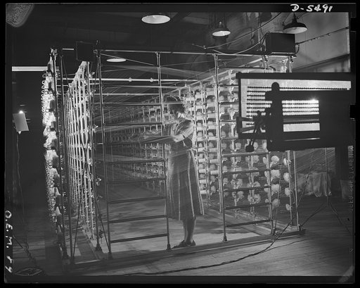 Production. Parachute cloth and shrouds. A warping machine for preparing nylon threads for the making of parachute cloth in an Eastern plant. This is one of the largest machines of highest speed in the country. It carries one thousand spools of nylon in its rack