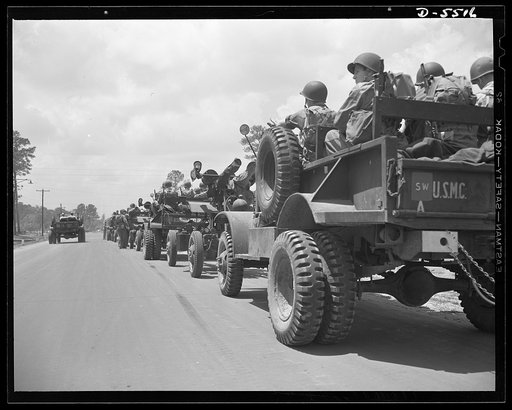 New River, North Carolina. Marine truck convoy. Tough fighting men who specialize in arriving at their destinations. A truck convoy of U.S. Marines, bristling with armament and ready for anything, rolls along a road near its New River, North Carolina base