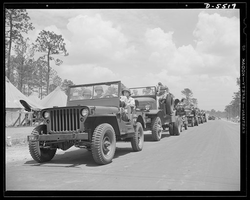 New River, North Carolina. Marine truck convoy. Tough fighting men who specialize in arriving at their destinations. A truck convoy of U.S. Marines, bristling with armament and ready for anything, rolls along a road near its New River, North Carolina base