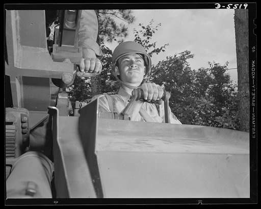 New River, North Carolina. Marine truck convoy. The leathernecks are good at this. A member of a Marine Corps truck convoy, in training at New River, North Carolina, operates the elevation lever of an anti-aircraft gun