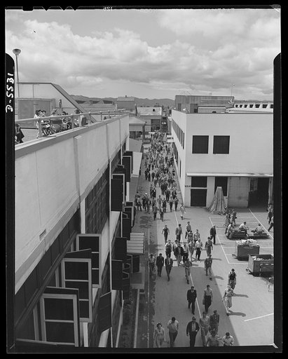 Production. Airplanes. "Main Street" of a huge Western aircraft plant during the lunch period. At left, girls enjoy lunch on a sun deck