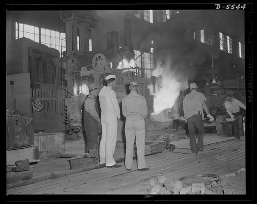 A poster comes to life. Standing in the white-hot glare of a twenty-five ton electric furnace where scrap metal and alloy materials are combined under terrific heat treatment, welder George Woolslayer tells Sergeant Vineyard and Chief Evans how this molten metal will be forged into the guns and tank