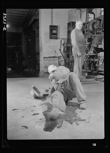 Industrial safety. Accident prevention. A careless employee has injured a fellow worker by leaving oil spilled on the floor. Clean floors are among the first considerations in a "good housekeeping" program
