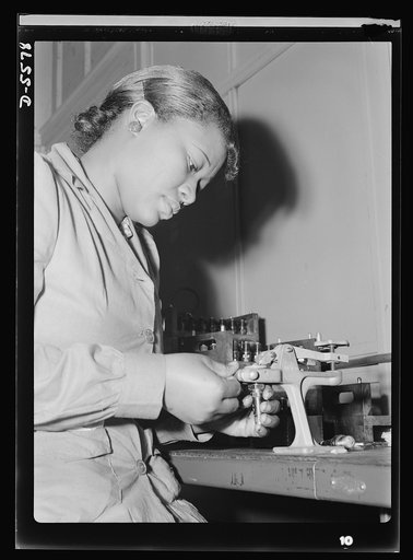 Production. Aircraft engines. Reconditioning used spark plugs for reuse in testing airplane motors, Mighnon Gunn operates this small testing machine with speed and precision although she was new to the job two months ago. A former domestic worker, this young woman is now a willing and efficient war 