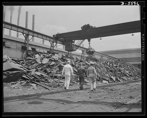 A poster comes to life. These piles of iron and steel collected from Uncle Sam's salvage drive are fast "getting in the scrap." Steelworker George Woolslayer shows Chief John Evans (left) and Sergeant French Vineyard one of the scrap yards at Allegheny- Ludlum where tons of old metal await loading i