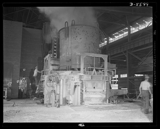A poster comes to life. Into this fifty-ton electric furnace at Allegheny-Ludlum, steelworkers load scrap materials which will be "cooked" into high alloy steel for America's ships and guns and tanks. Allegheny-Steel, Pittsburgh, Pennsylvania
