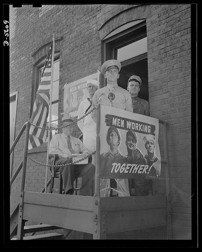 A poster comes to life. "Up until my visit here I thought it was just the Army that was fighting this war." Speaking before the assembled steel workers at Allegheny-Ludlum, Sergeant Vineyard acknowledges the debt of the armed forces to the men "behind the men behind the guns." This meeting was arran