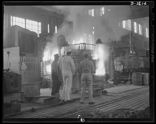 A poster comes to life. Standing in the white-hot glare of a twenty-five ton electric furnace where scrap metal and alloy materials are combined under terrific heat treatment, welder George Woolslayer tells Sergeant Vineyard and Chief Evans how this molten metal will be forged into the guns and tank