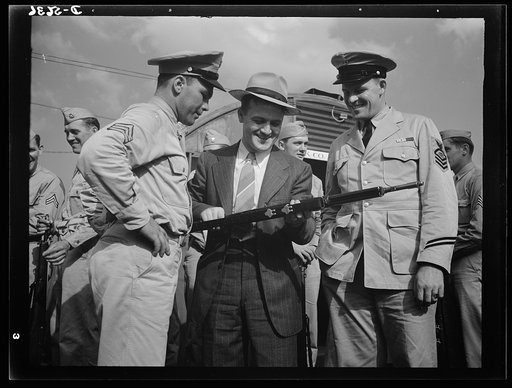 A poster comes to life. A reciprocal engagement is carried out at Sergeant Vineyard's army post, where welder George Woolslayer and Aviation-radio Chief John Marshall Evans (right) learn about life in the Army. Woolslayer was invited to the post after he had shown the servicemen through the steel mi