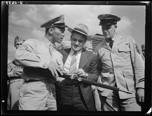A poster comes to life. A reciprocal engagement is carried out at Sergeant Vineyard's army post, where welder George Woolslayer and Aviation-radio Chief John Marshall Evans (right) learn about life in the Army. Woolslayer was invited to the post after he had shown the servicemen through the steel mi