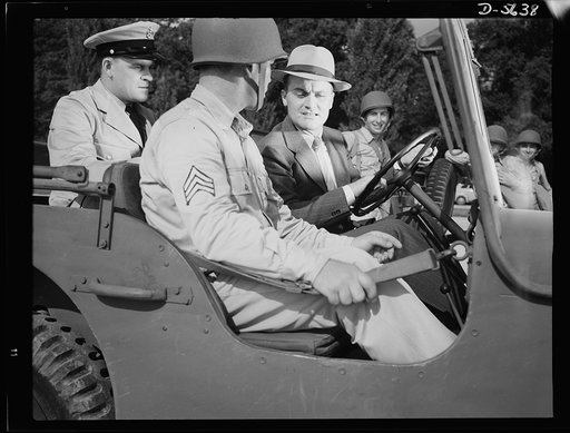 A poster comes to life. "Never got so close to one of these babies before" says George Woolslayer (right) giving an army jeep the once-over. At the post where Sergeant French L. Vineyard (center) is stationed, Woolslayer learned a great many things about army operations. Aviation-radio Chief John Ma