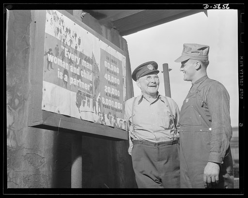 A poster comes to life. Woolslayer interrupts the tour to chat with one of the plant guards, a veteran employee. The poster was designed by the same government office responsible for the "Men Working Together" poster. Allegheny-Steel, Pittsburgh, Pennsylvania