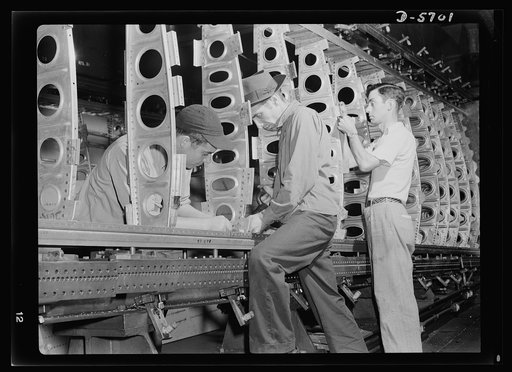 Production. Willow Run bomber plant. The outer wing panel of a bomber undergoes assembly in the giant Willow Run plant. When finished, this section will be removed and cranes will install another section in the fixture. Ford plant, Willow Run