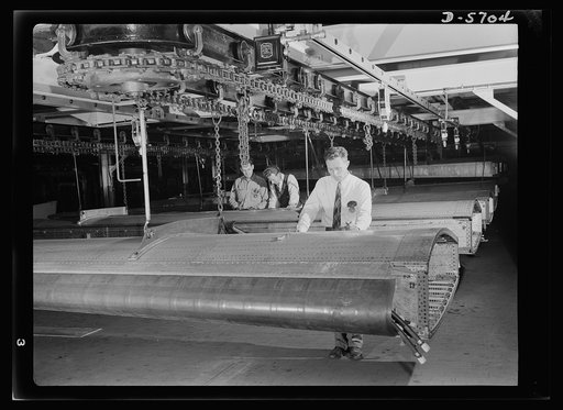 Production. Willow Run bomber plant. Checking almost-completed wing structure with blueprints, engineers at the great Willow Run bomber plant determine next steps to be taken before the wings leave the assembly line. Ford plant, Willow Run
