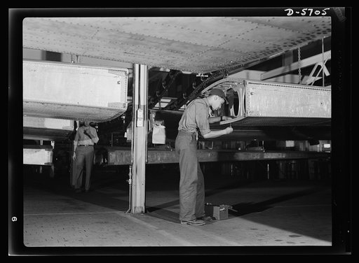 Production. Willow Run bomber plant. Negro worker at Willow Run installs screws in wing segment of a bomber. Note underside of wing, above. Ford plant, Willow Run