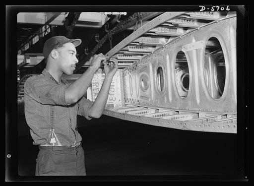 Production. Willow Run bomber plant. A Negro worker at the giant Willow Run bomber plant installs screws in one end of a wing segment