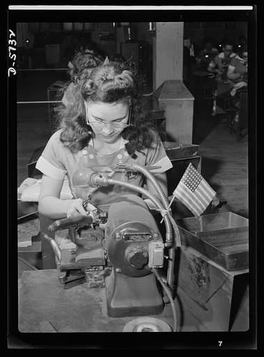 Women in industry. Tool  production. Her mind's on her work and on her country. That small flag tells the story of this young woman's absorption in her job. Employed by a Midwest drill and tool plant, she's grinding points on drills which will be used in the production of America's ships and planes 