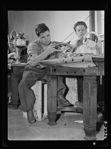 Manpower. Handicapped workers. Ineligible for the army because of physical handicaps, James C. Schneider (left) and John D. Arrowood are two of Uncle Sam's ablest soldiers of production. They are inspectors of airplane motor parts in a Baltimore factory. Twenty-year-old Schneider has not let infanti