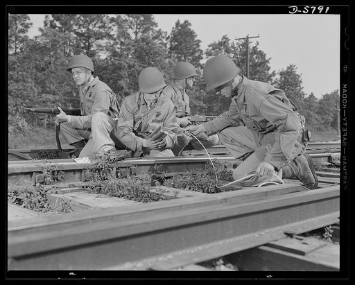 New River, North Carolina. Marine Corps demolition squads. The leathernecks can destroy railway systems, as well as build and operate them. A Marine demolition squad, in training at the New River, North Carolina base, prepares to blow out a section of track. Two men set the charge while two others s