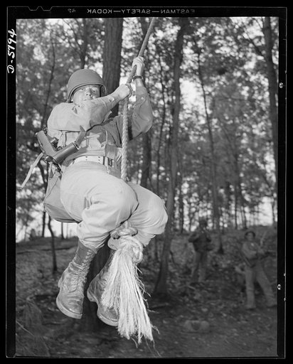 New River, North Carolina. Marines in training. "Walking" up a rope hand over hand with full combat pack is an approved toughening-up exercise at the New River, North Carolina Marine base. Leathernecks who go in for conditioning routines like this will give the Axis some new ideas of what a hard-boi