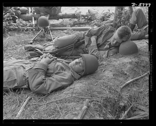 New River, North Carolina. Marines in training. A little "shuteye" goes good after a hard workout in a training area. Toughened Marines make pillows and nightcaps of their steel helmets during a brief pause in the grueling war exercises at New River, North Carolina. Marine barracks, New River, North