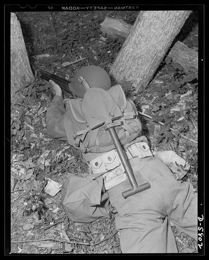 New River, North Carolina. Marines in training. Your modern leatherneck doesn't need a plumber's helper. When he goes into battle he carries the tools of his trade with him. He knows how to take advantage of all natural cover, as witnessed in the setup this man has made for himself during Marine war
