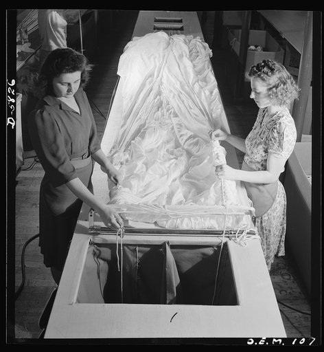 Production. Parachute making. As these two girls thread shroud cords through the material, these yards of silk become more nearly recognizable as one of the parachutes turned out by this Eastern plant. Pioneer Parachute Company, Manchester, Connecticut