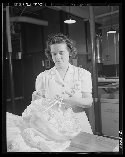 Production. Parachute making. Final inspection of flare parachutes is as important to this worker as inspection of parachutes that will carry "live cargo." Location: an Eastern parachute plant. Pioneer Parachute Company, Manchester, Connecticut