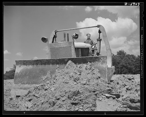 Fort Knox. Earth moving equipment. A new access road to Fort Knox, Kentucky begins to take form as a bulldozer and tractor blade the earth into place during early grading operations