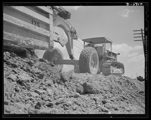 Fort Knox. Earth moving equipment. A huge carryall scraper and a powerful tractor work on a cut-and-fill job as a new access road is built at Fort Knox, Kentucky