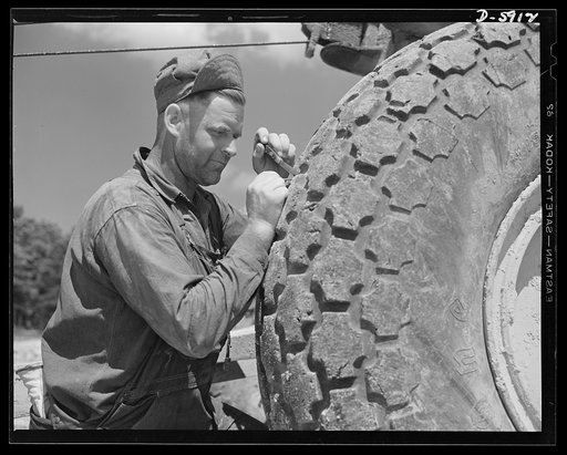 Fort Knox. Earth moving equipment. The big "shoes" of a carryall scraper, working on a new access road at Fort Knox, Kentucky, are given the best of care. A mechanic removes nails and bits of glass and metal from a costly tire that must give many more miles of service