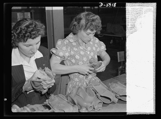 Women in industry. Gas mask production. Don't let their youth and good looks deceive you, these two young workers are actually full-fledged government inspectors who are employed in a converted Midwest vacuum cleaner plant to test gas masks. Every one of the hundreds of rubber masks that move along 