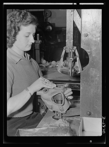 Women in industry. Gas mask production. Formerly a beauty shop operator, blonde Marjorie Karwaske finds that the dear dead days of bobby pins and curler clamps have left her with skillful, speedy fingers and a natural tendency to eliminate wasteful hand movement. These are invaluable aids to her job