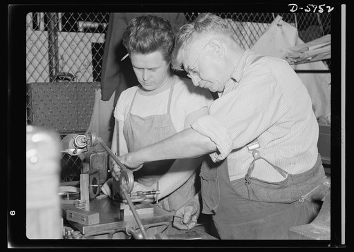 Manpower. Americans all. Their common hatred of fascism bridges the gulf in ancestory of these two Americans, one of Irish descent, the other born in Rumania. Working together with one urgent goal uppermost in mind - victory for the United Nations. J.Powers (left) and J.M. Deli are processing parts 