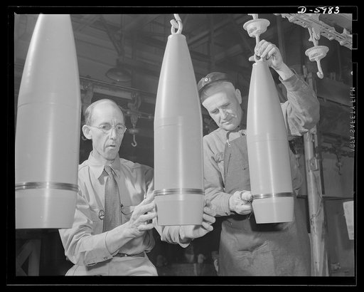 Production. 155mm shells. Government inspectors check the painting of 155mm shells as they pass by on the overhead drying conveyor of a converted auto plant. Willy's, Toledo, Ohio