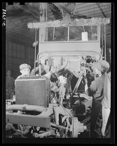 Production. Jeeps. Another jeep for our armed forces nears completion. A body is lowered into place on a chassis in a large Midwest auto plant. Willy's, Toledo, Ohio