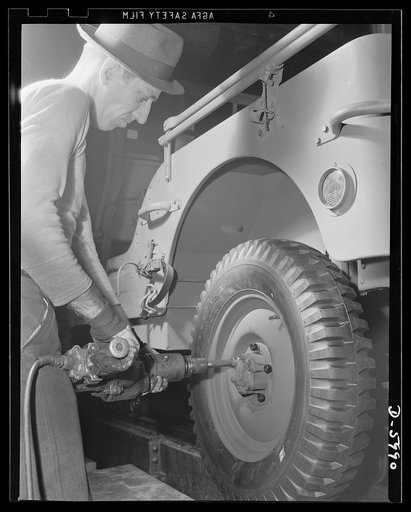 Production. Jeeps. Putting "shoes" on another hard-boiled recruit. An army jeep nears completion in a big Midwest auto plant. Willy's, Toledo, Ohio