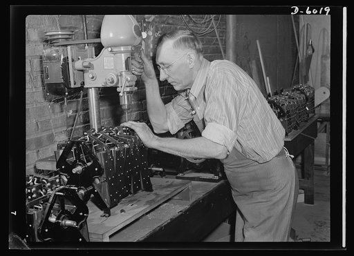 Conversion. Pianos to airplane motors. Using the same drill press which once assembled piano parts, this employee of a Chicago firm now installs gears in the pneumatic motors of trainer planes. The factory has stopped piano production for the duration and now produces trainer-plane motors for Americ